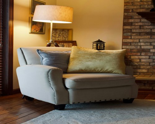 A comfortable armchair with a warm reading lamp in a softly lit living room