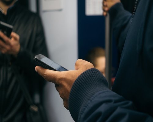 Commuter holding a smartphone safely during a public transport ride